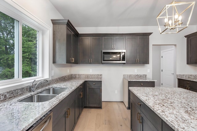 29126 Brooke Meadows Ct, Chesterfield, MI 48047 - kitchen featuring stainless steel appliances, a sink, dark brown cabinets, light wood finished floors, and light stone counters