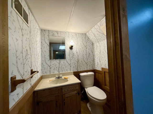 2222 Compton St, Saginaw, MI 48602 - half bathroom with wallpapered walls, toilet, vanity, wainscoting, and tile patterned flooring