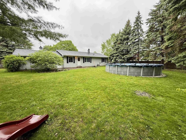 2222 Compton St, Saginaw, MI 48602 - rear view of house featuring a yard and a covered pool