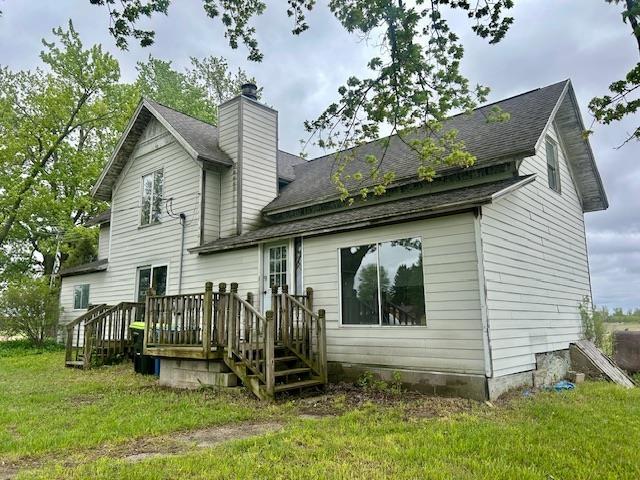 4992 Freeman Rd, Beaverton, MI 48612 - back of property with a deck, a lawn, a chimney, and roof with shingles