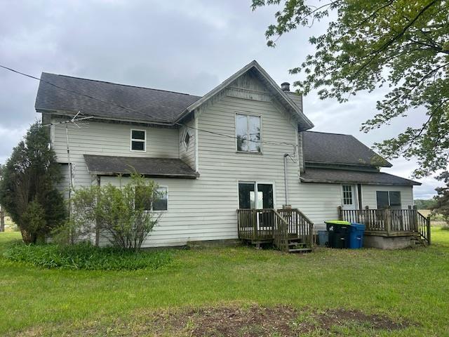 4992 Freeman Rd, Beaverton, MI 48612 - rear view of house featuring a yard, a chimney, a deck, and a shingled roof