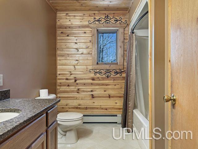 7730 Tipperary Ave, Gladstone, MI 49837 - bathroom with a baseboard heating unit, vanity, toilet, shower / tub combo with curtain, and wooden ceiling