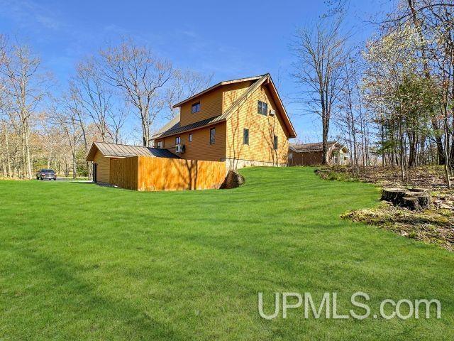 7730 Tipperary Ave, Gladstone, MI 49837 - view of property exterior with a yard and metal roof