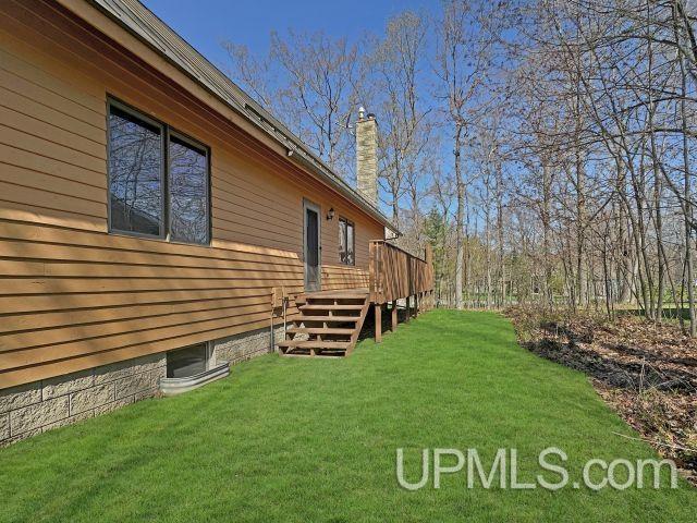 7730 Tipperary Ave, Gladstone, MI 49837 - view of grassy yard featuring a deck and stairway