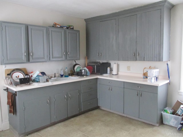 405 W S Ave Unit 1, Houghton, MI 49931 - kitchen with stainless steel microwave, gray cabinetry, a sink, and light countertops
