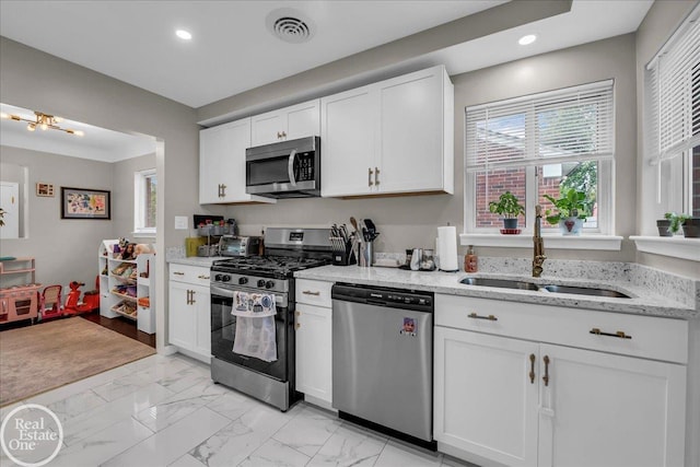 24080 Scotia Rd, Oak Park, MI 48237 - kitchen with appliances with stainless steel finishes, a sink, light marble finish floors, recessed lighting, and white cabinetry