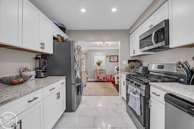 24080 Scotia Rd, Oak Park, MI 48237 - kitchen featuring appliances with stainless steel finishes, recessed lighting, light marble finish flooring, white cabinetry, and light stone counters