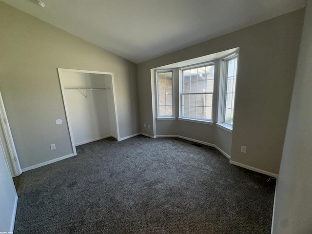 16180 Scenic Dr, Clinton, MI 48038 - unfurnished bedroom with vaulted ceiling, dark carpet, baseboards, and a closet