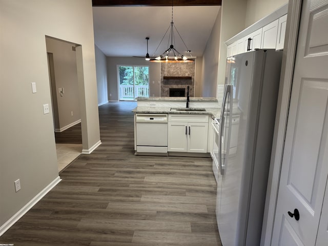 16180 Scenic Dr, Clinton, MI 48038 - kitchen with white appliances, open floor plan, a sink, a peninsula, and vaulted ceiling