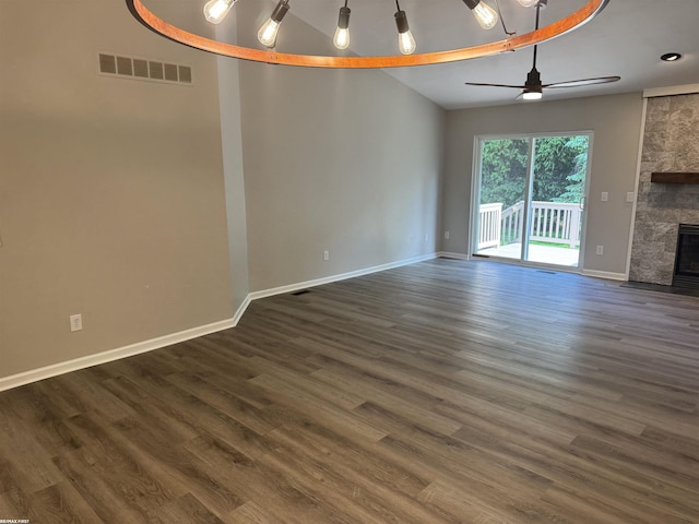 16180 Scenic Dr, Clinton, MI 48038 - unfurnished living room featuring a fireplace, baseboards, dark wood-type flooring, and vaulted ceiling