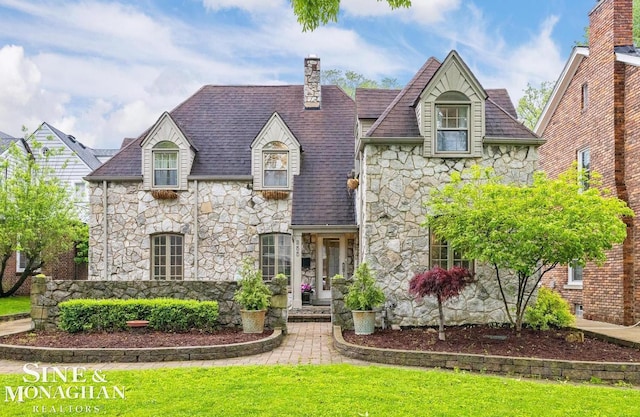 255 Lewiston Rd, Grosse Pointe Farms, MI 48236 - french country style house with stone siding, a front yard, and a chimney