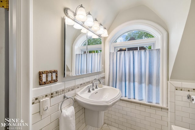 255 Lewiston Rd, Grosse Pointe Farms, MI 48236 - bathroom with tile walls, lofted ceiling, and a wainscoted wall