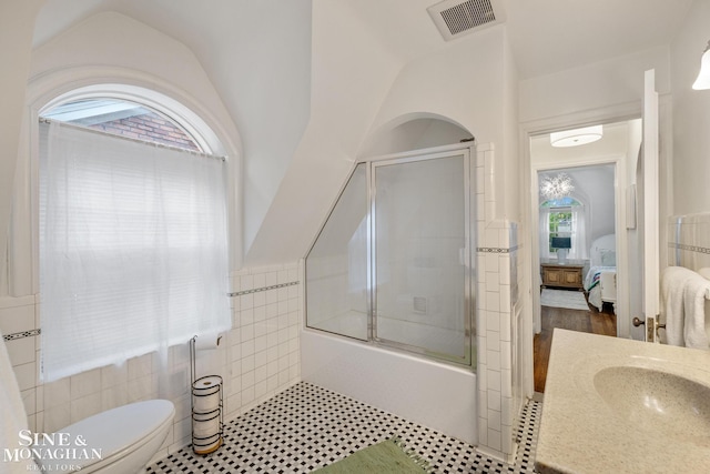 255 Lewiston Rd, Grosse Pointe Farms, MI 48236 - ensuite bathroom with combined bath / shower with glass door, toilet, vanity, and tile walls