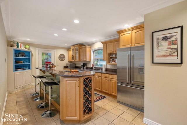 255 Lewiston Rd, Grosse Pointe Farms, MI 48236 - kitchen with high end fridge, light tile patterned flooring, a kitchen breakfast bar, recessed lighting, and glass insert cabinets