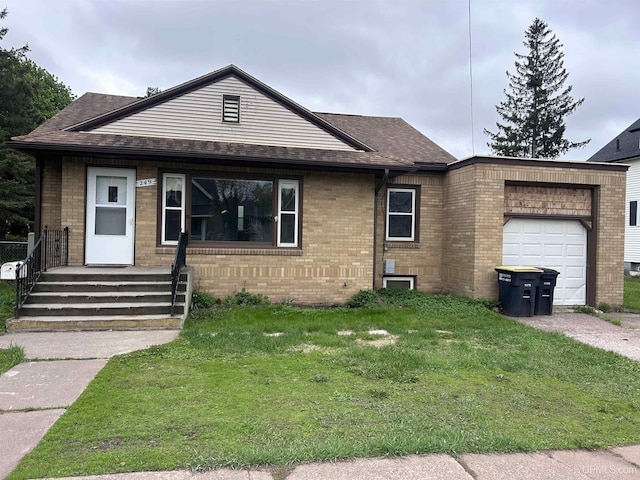 249 E Michigan Ave, Ironwood, MI 49938 - view of front of house featuring an attached garage, brick siding, a front lawn, roof with shingles, and driveway