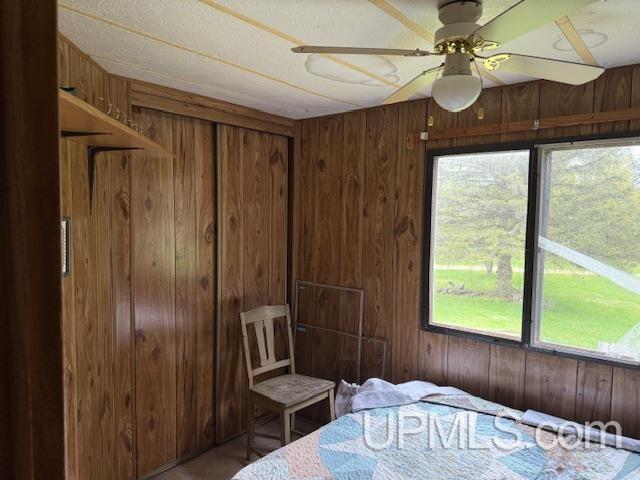 11843 Howen Rd, Long Lake T-Wi, WI 54542 - bedroom with wood walls and ceiling fan