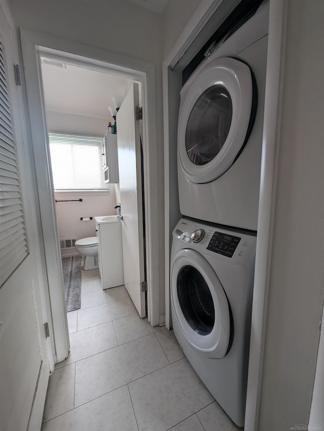 13610 Gander Ave, Warren, MI 48088 - laundry room with stacked washer / drying machine and light tile patterned floors