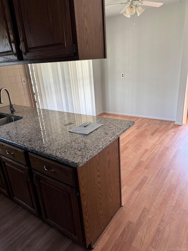 28724 Sutherland Dr, Warren, MI 48088 - kitchen featuring ceiling fan, tasteful backsplash, a sink, stone counters, and light wood-style flooring