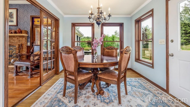 1128 E E St, Iron Mountain, MI 49801 - dining area with a chandelier, healthy amount of natural light, light wood finished floors, crown molding, and baseboards