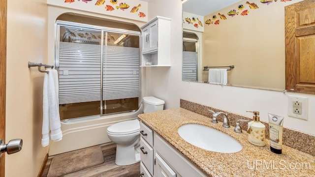 1128 E E St, Iron Mountain, MI 49801 - bathroom with vanity, toilet, shower / bath combination with glass door, and wood finished floors