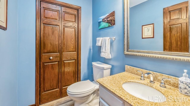 1128 E E St, Iron Mountain, MI 49801 - bathroom featuring vanity, toilet, and a closet