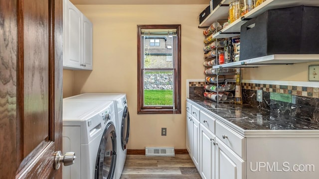 1128 E E St, Iron Mountain, MI 49801 - washroom with cabinet space, light wood-style floors, washer and dryer, and baseboards