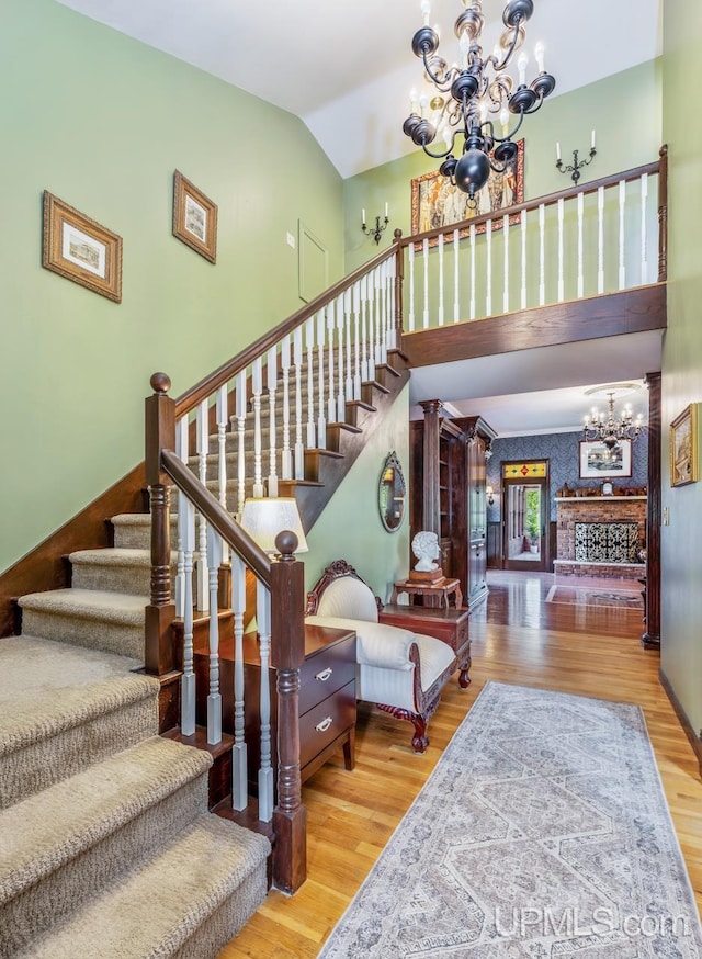 1128 E E St, Iron Mountain, MI 49801 - stairs with a chandelier, wood finished floors, and lofted ceiling