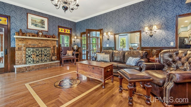 1128 E E St, Iron Mountain, MI 49801 - living area featuring wallpapered walls, a chandelier, wood finished floors, wainscoting, and ornamental molding