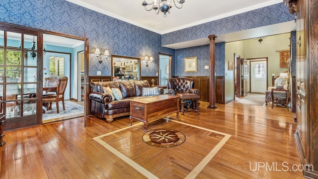 1128 E E St, Iron Mountain, MI 49801 - living area with wallpapered walls, a chandelier, ornamental molding, wainscoting, and light wood-type flooring