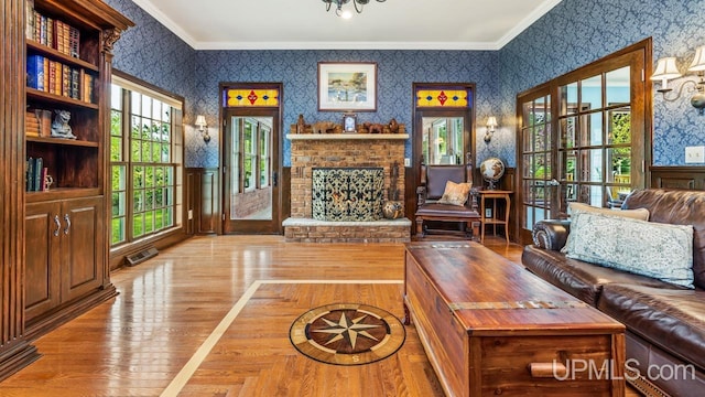 1128 E E St, Iron Mountain, MI 49801 - living room with wallpapered walls, ornamental molding, wood finished floors, and a brick fireplace