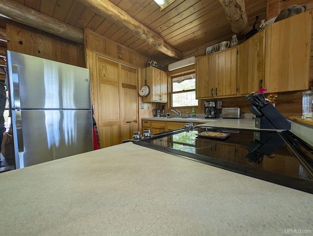 4537 Ii Rd, Garden, MI 49835 - kitchen featuring freestanding refrigerator, wooden ceiling with exposed beams, brown cabinetry, light countertops, and wooden walls