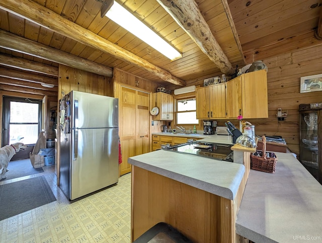 4537 Ii Rd, Garden, MI 49835 - kitchen with freestanding refrigerator, light countertops, wooden ceiling with exposed beams, a peninsula, and wood walls