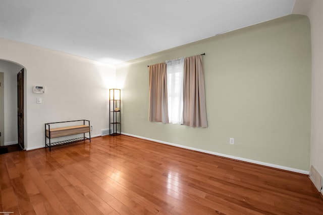20681 Beaufait St, Harper Woods, MI 48225 - spare room featuring arched walkways, wood-type flooring, and baseboards