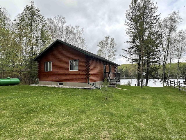 2966 Sycamore Ln, Republic, MI 49879 - view of home's exterior featuring log exterior, a water view, and a lawn