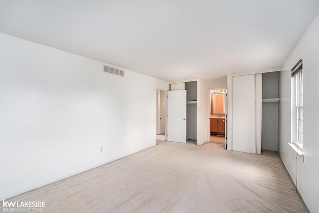 6019 Kingsfield Dr, West Bloomfield, MI 48322 - unfurnished bedroom featuring two closets, light colored carpet, and ensuite bathroom