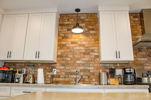 19390 W Calverley St, Houghton, MI 49931 - kitchen featuring wall chimney exhaust hood, a sink, tasteful backsplash, and white cabinetry