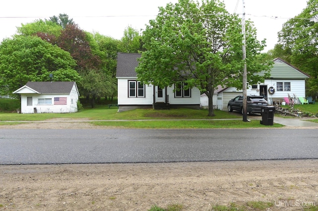 22019 E Everett Ave, Grand Marais, MI 49839 - view of front of house with driveway, a front lawn, and a shingled roof