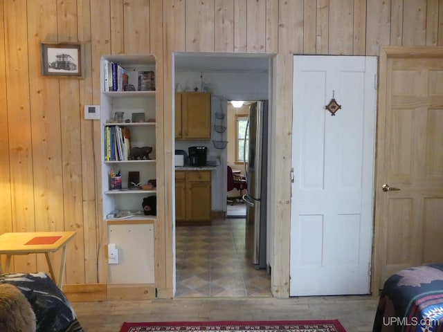22019 E Everett Ave, Grand Marais, MI 49839 - bedroom featuring wood walls, freestanding refrigerator, and tile patterned floors