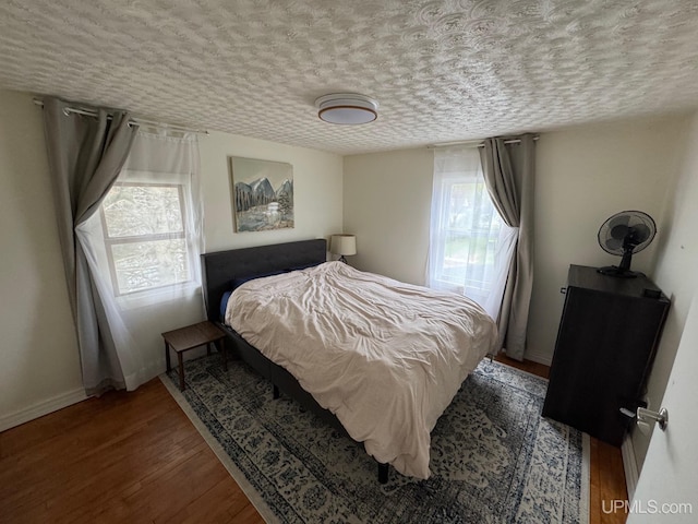 809 W A St, Iron Mountain, MI 49801 - bedroom featuring multiple windows, wood finished floors, baseboards, and a textured ceiling