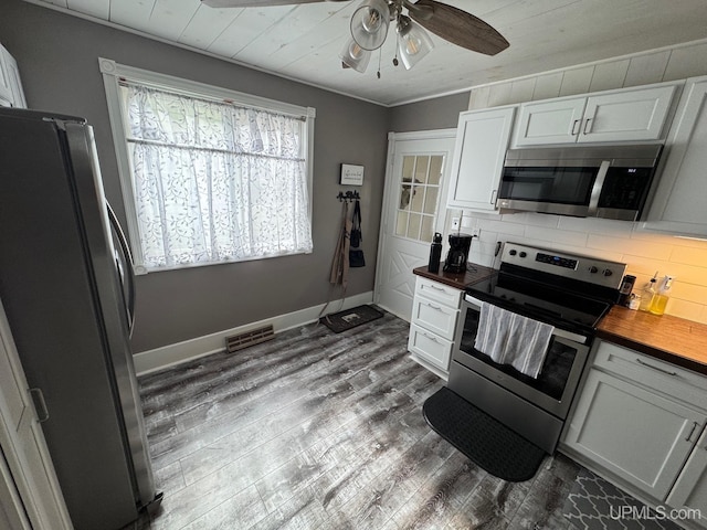 809 W A St, Iron Mountain, MI 49801 - kitchen with stainless steel appliances, ceiling fan, dark wood-type flooring, backsplash, and wood counters