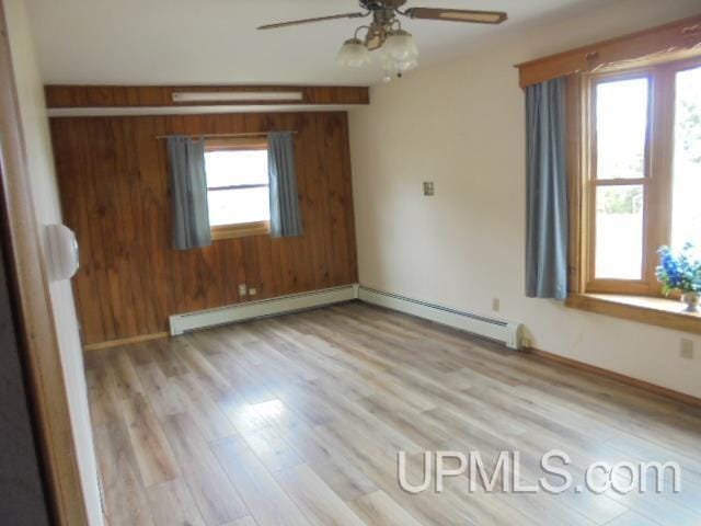 605 W 5th St, Rockland, MI 49960 - spare room featuring ceiling fan, wood finished floors, baseboard heating, and baseboards
