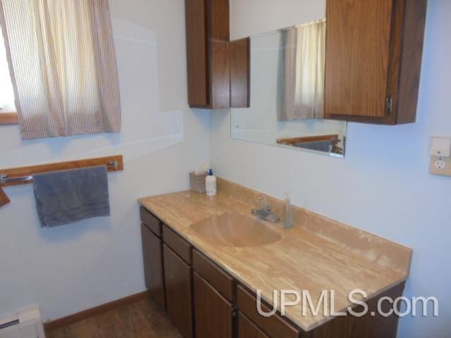 605 W 5th St, Rockland, MI 49960 - bathroom featuring vanity and baseboard heating