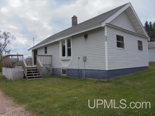 605 W 5th St, Rockland, MI 49960 - view of home's exterior featuring a chimney, a yard, and a wooden deck