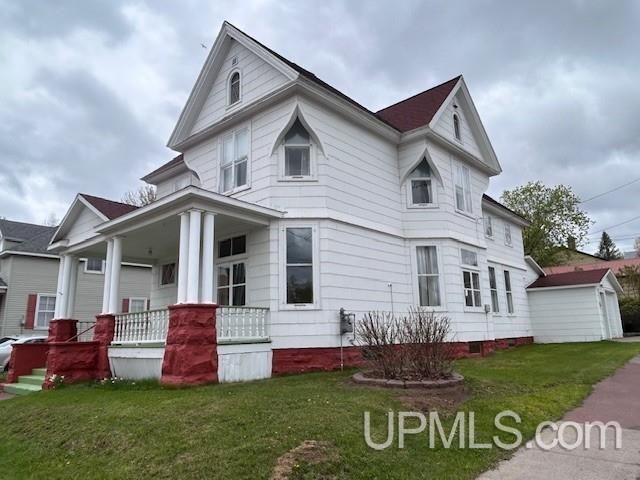 708 Calumet St, Lake Linden, MI 49945 - view of front facade featuring covered porch, a front yard, and an outdoor structure