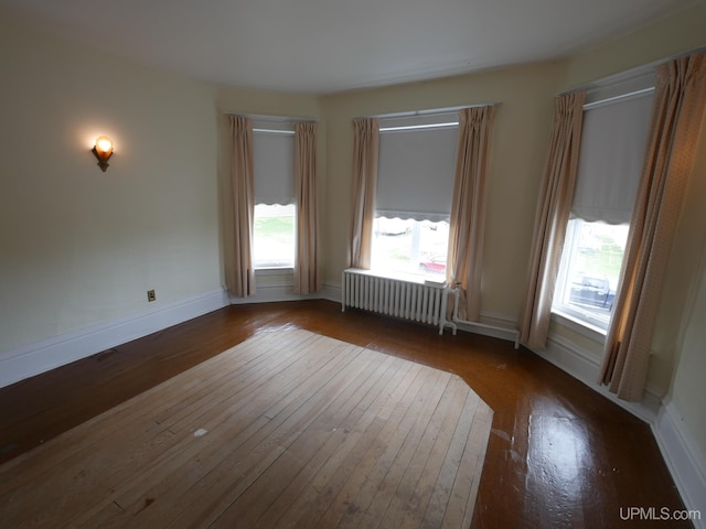 708 Calumet St, Lake Linden, MI 49945 - spare room with radiator heating unit, hardwood / wood-style flooring, healthy amount of natural light, and baseboards