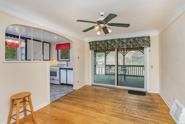 107 State Park Dr, Bay City, MI 48706 - unfurnished dining area with wood finished floors, ceiling fan, arched walkways, and baseboards