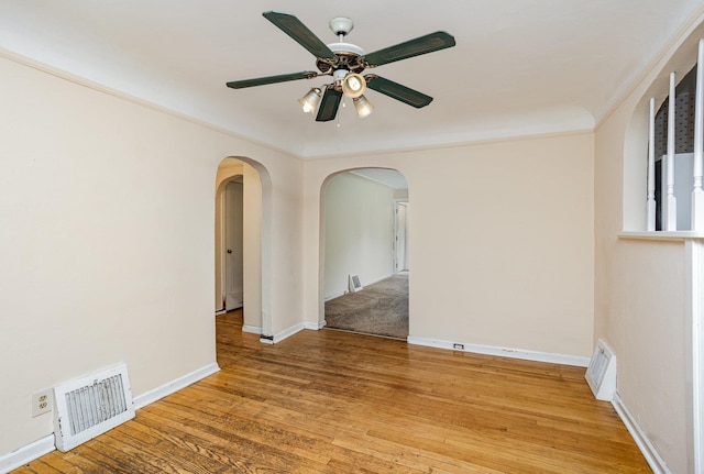 107 State Park Dr, Bay City, MI 48706 - unfurnished room with arched walkways, a ceiling fan, light wood finished floors, and baseboards