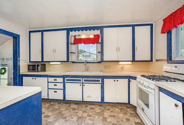 107 State Park Dr, Bay City, MI 48706 - kitchen with gas range gas stove, a sink, stainless steel microwave, light countertops, and wallpapered walls