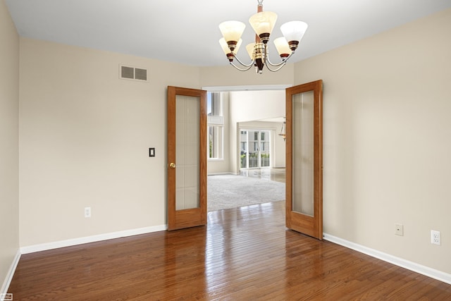 51461 Silver Bell Dr, Macomb Twp, MI 48042 - empty room with a chandelier, wood finished floors, and baseboards