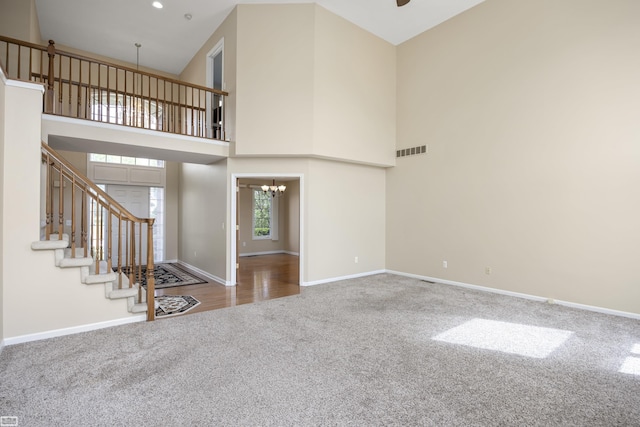 51461 Silver Bell Dr, Macomb Twp, MI 48042 - unfurnished living room featuring carpet floors, a chandelier, baseboards, a high ceiling, and stairs